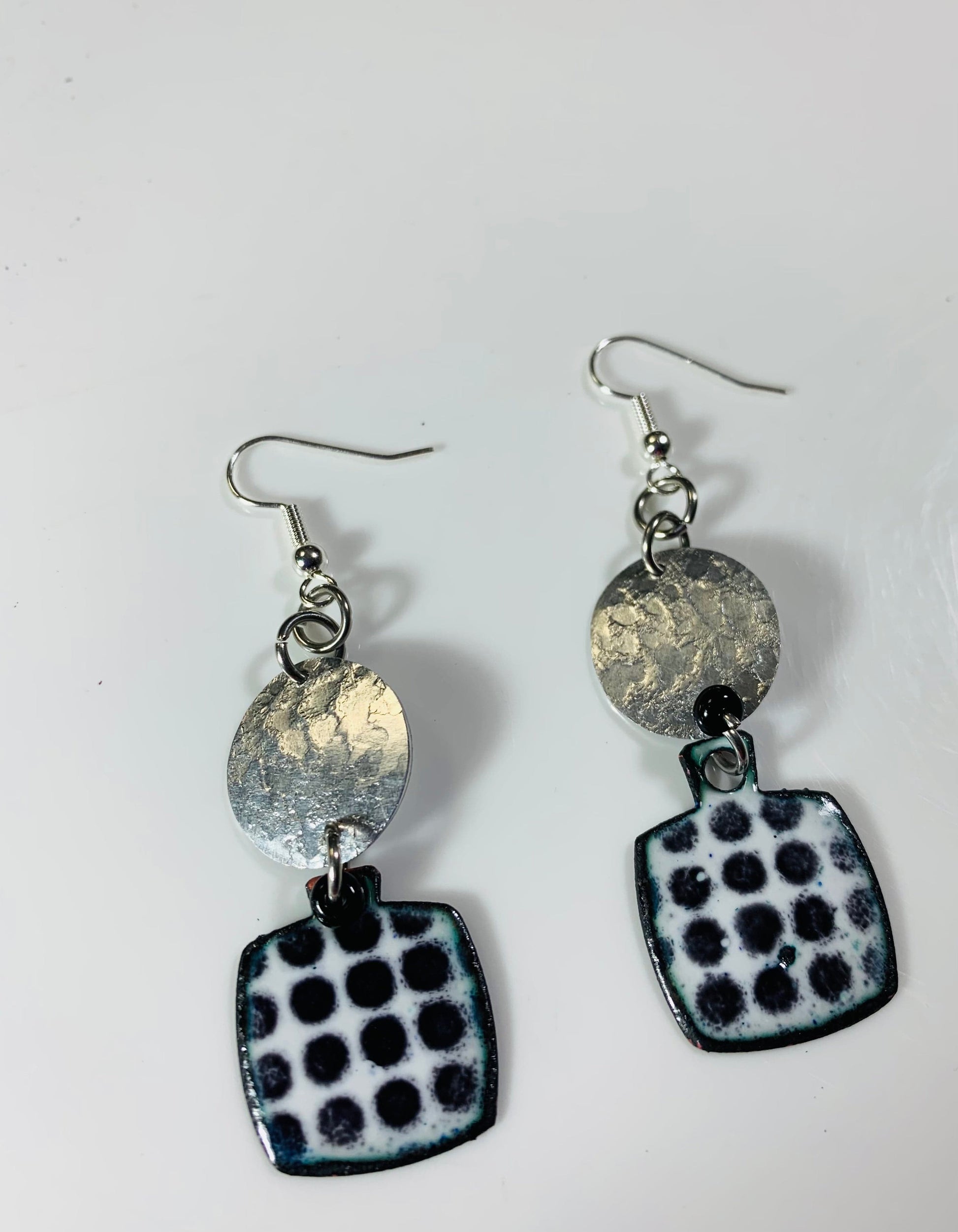 Silver earrings with black polka dot detail