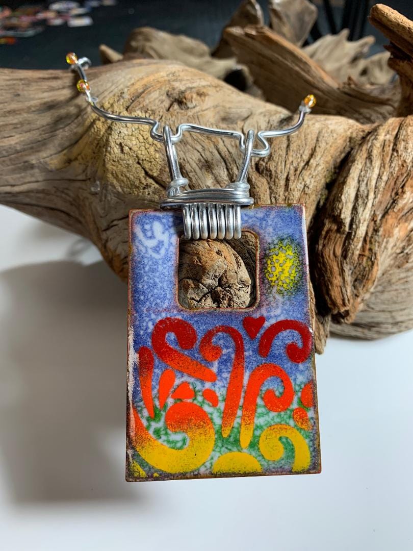 Bursting enamel pendant necklace on driftwood