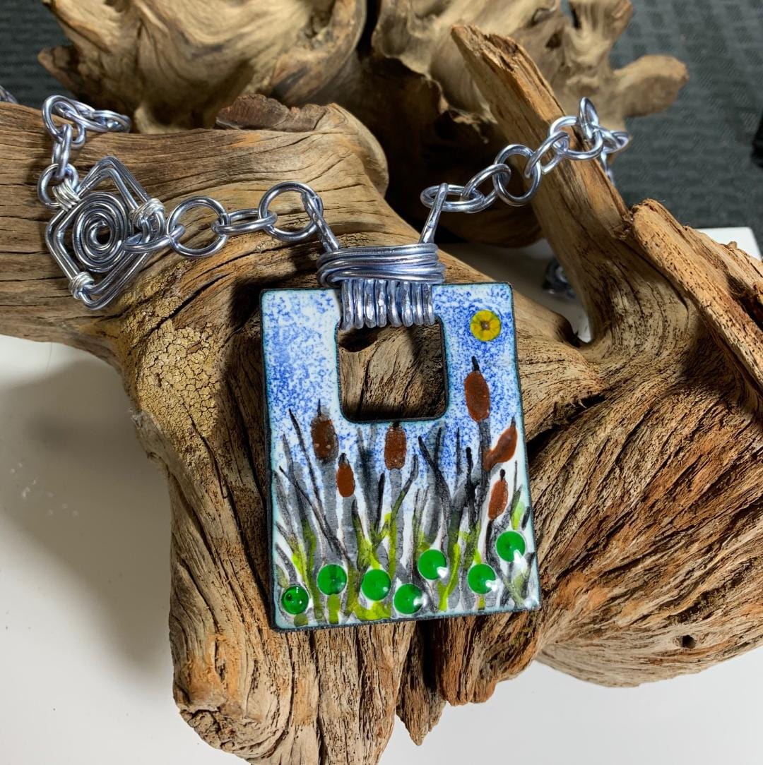 Cat Tails pond necklace with silver chain on driftwood