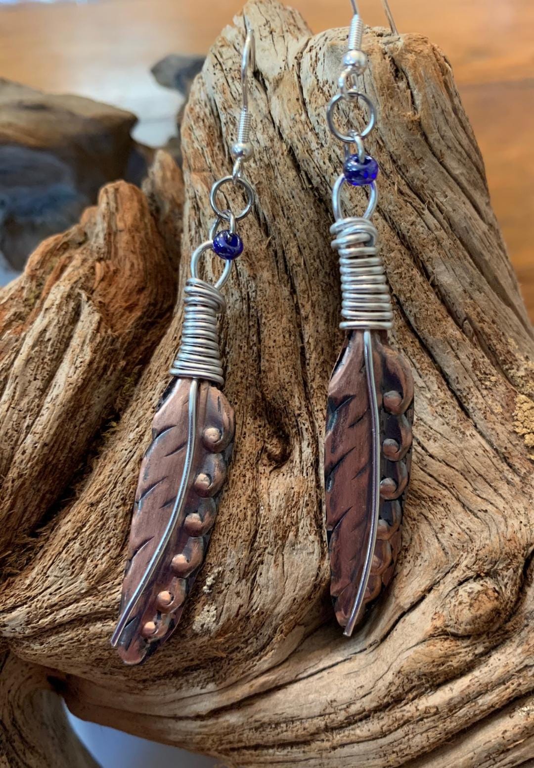 Copper feather earrings with blue bead accents