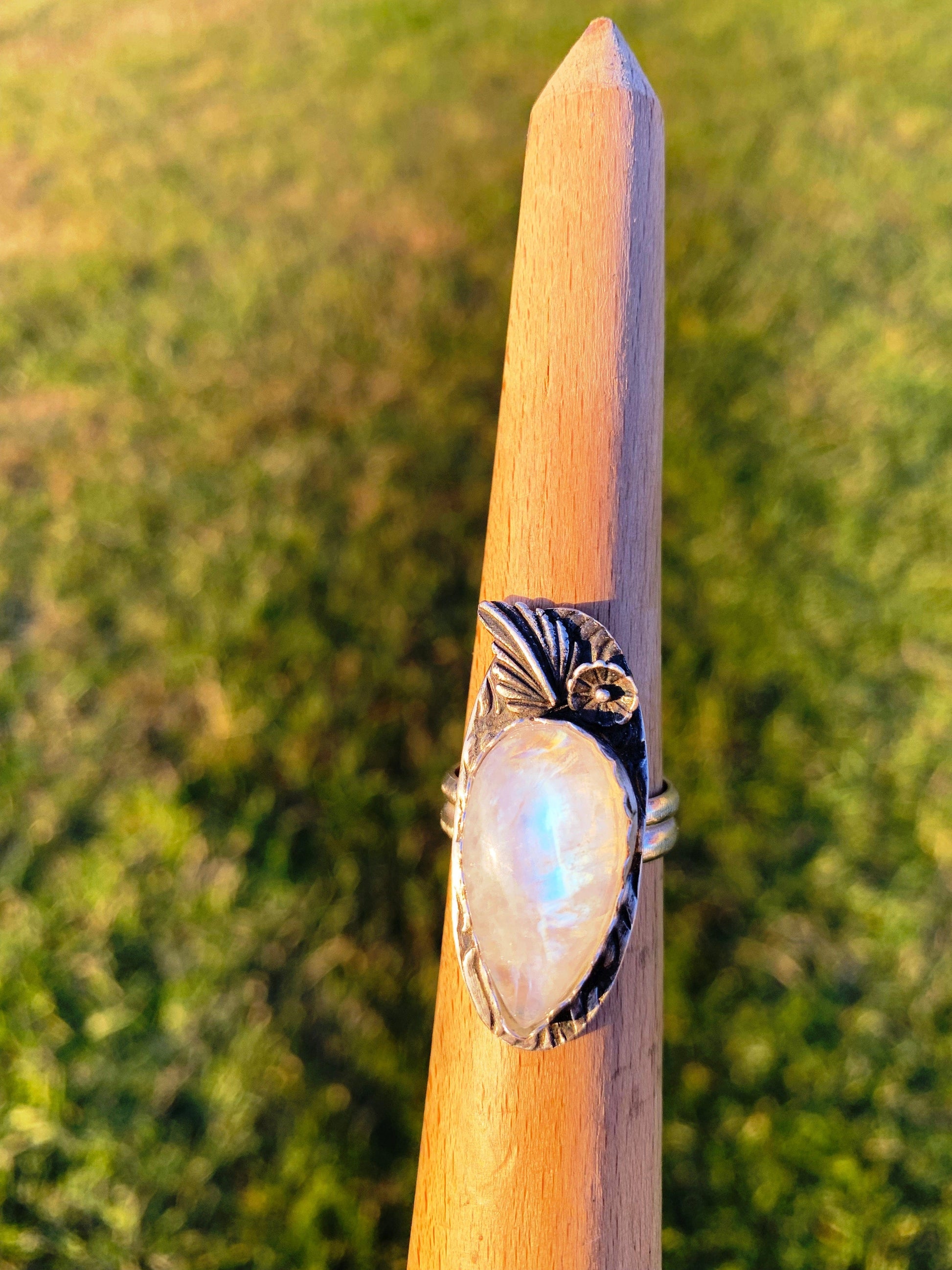 Moonstone flower ring on wooden stand