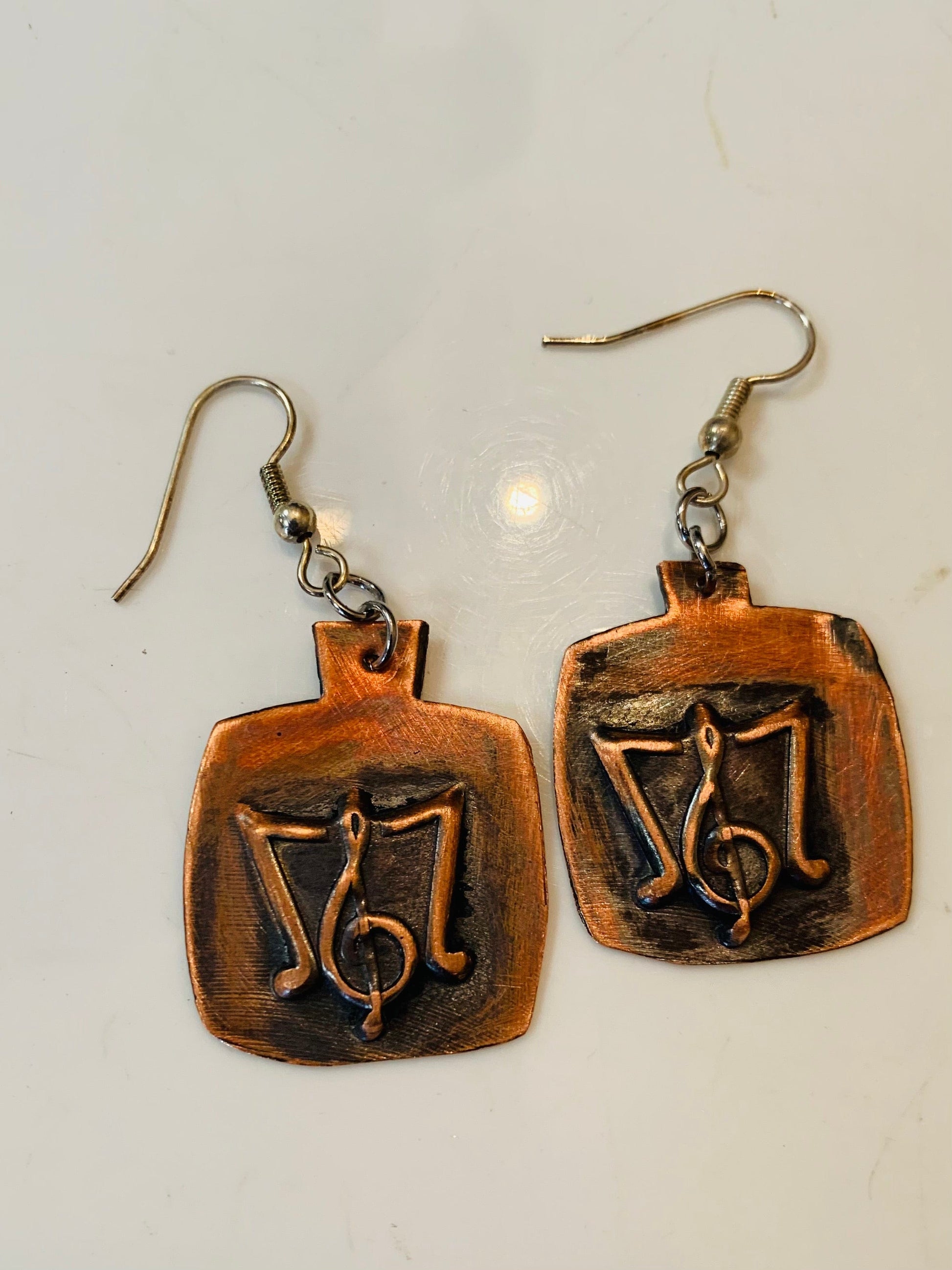 Music staff earrings with treble clef and copper finish.