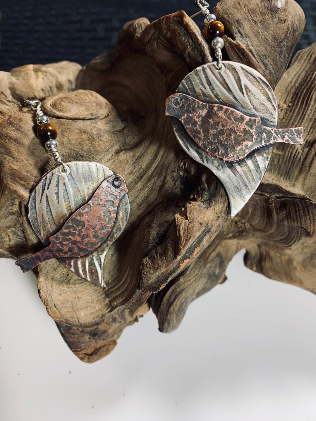 Silver Bird earrings on wood