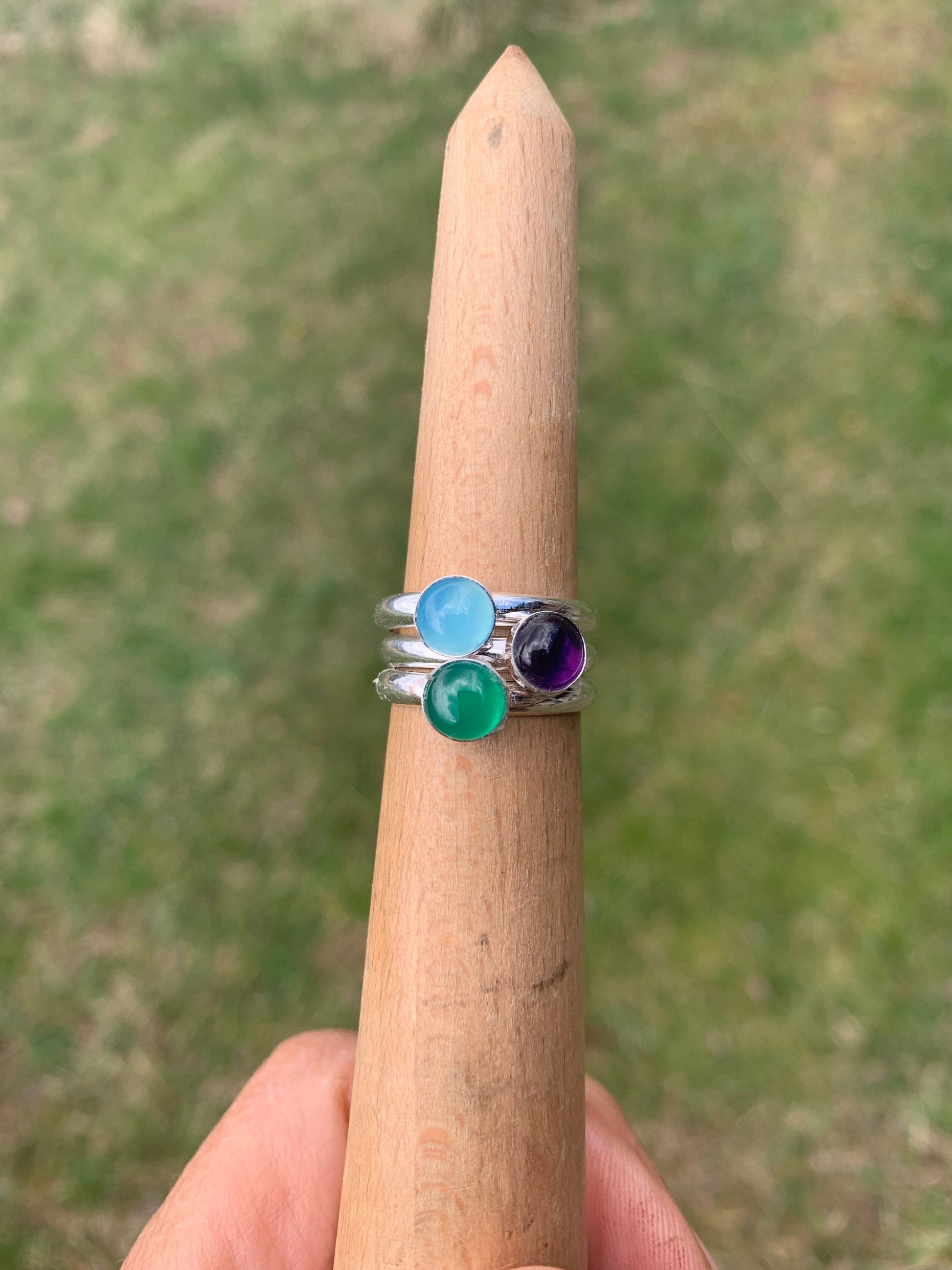 Stackers6 rings with blue, green, and purple gemstones.