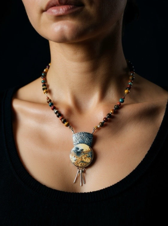 Necklace with a large pendant worn by a person against a black background