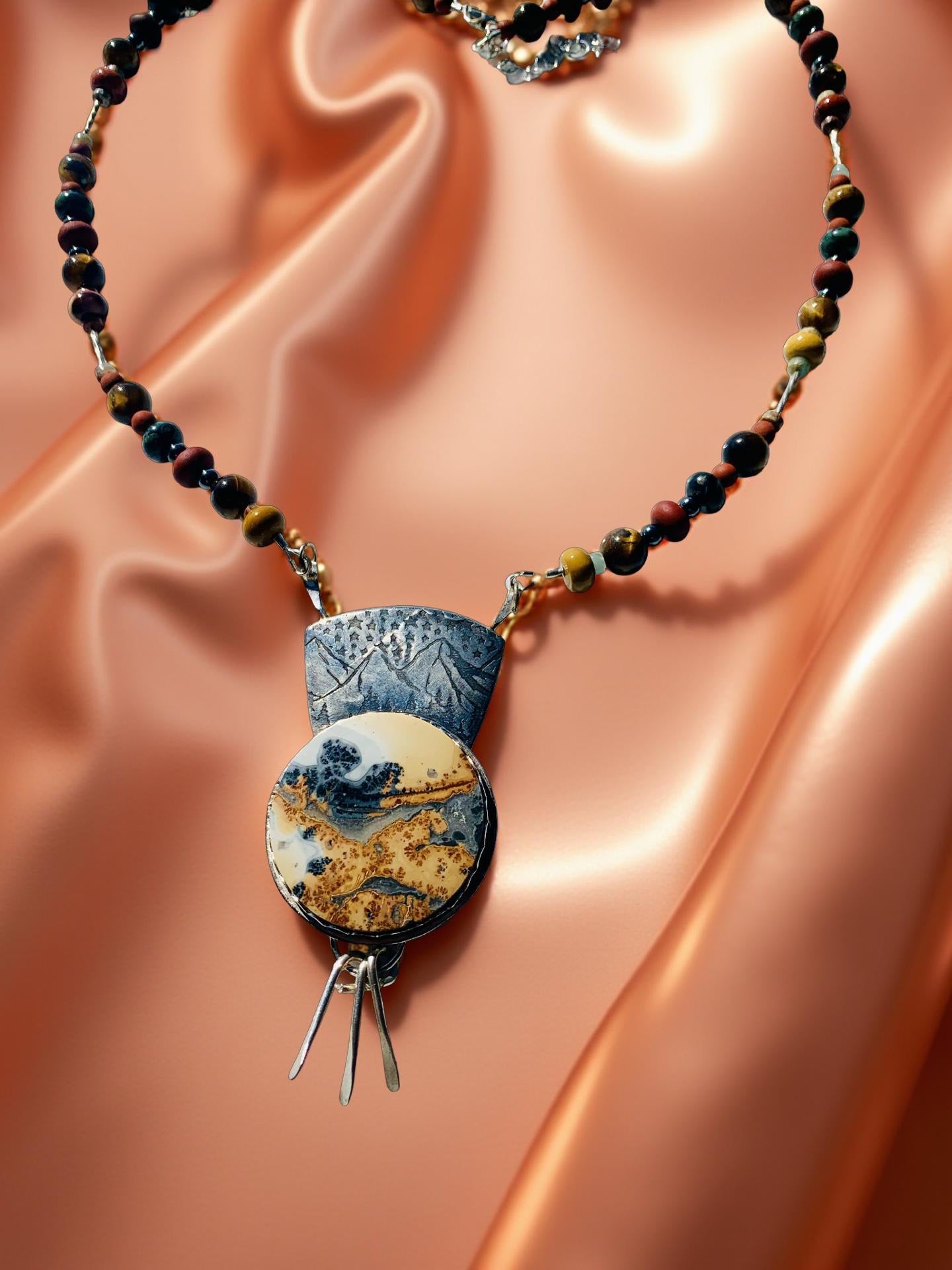 Necklace with a pendant on a peach-colored fabric background