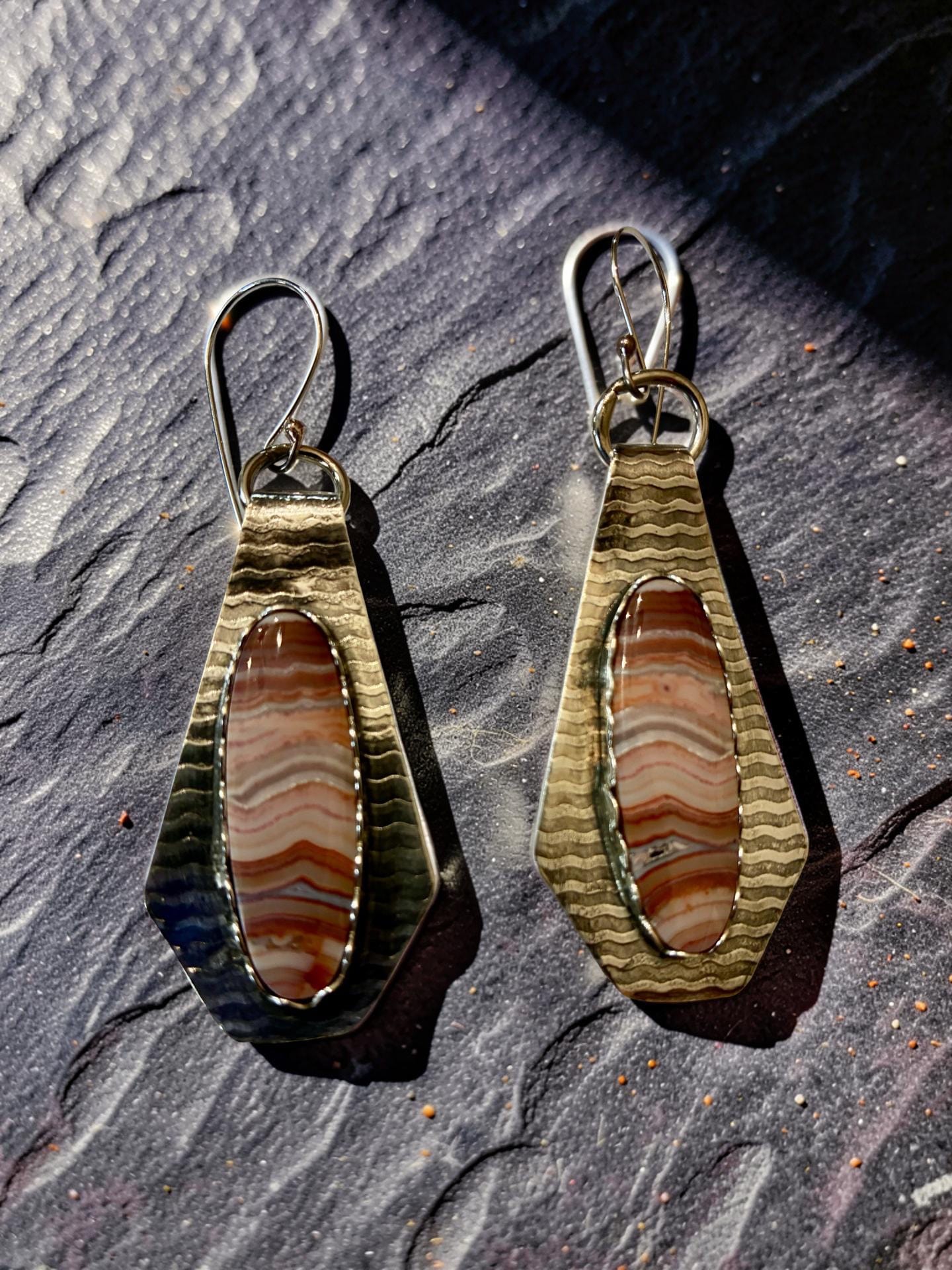 One-of-a-kind sterling silver earrings featuring elongated earth-tone Banded Crazy Lace Agate stones in hand-textured silver settings with handcrafted earwires.
