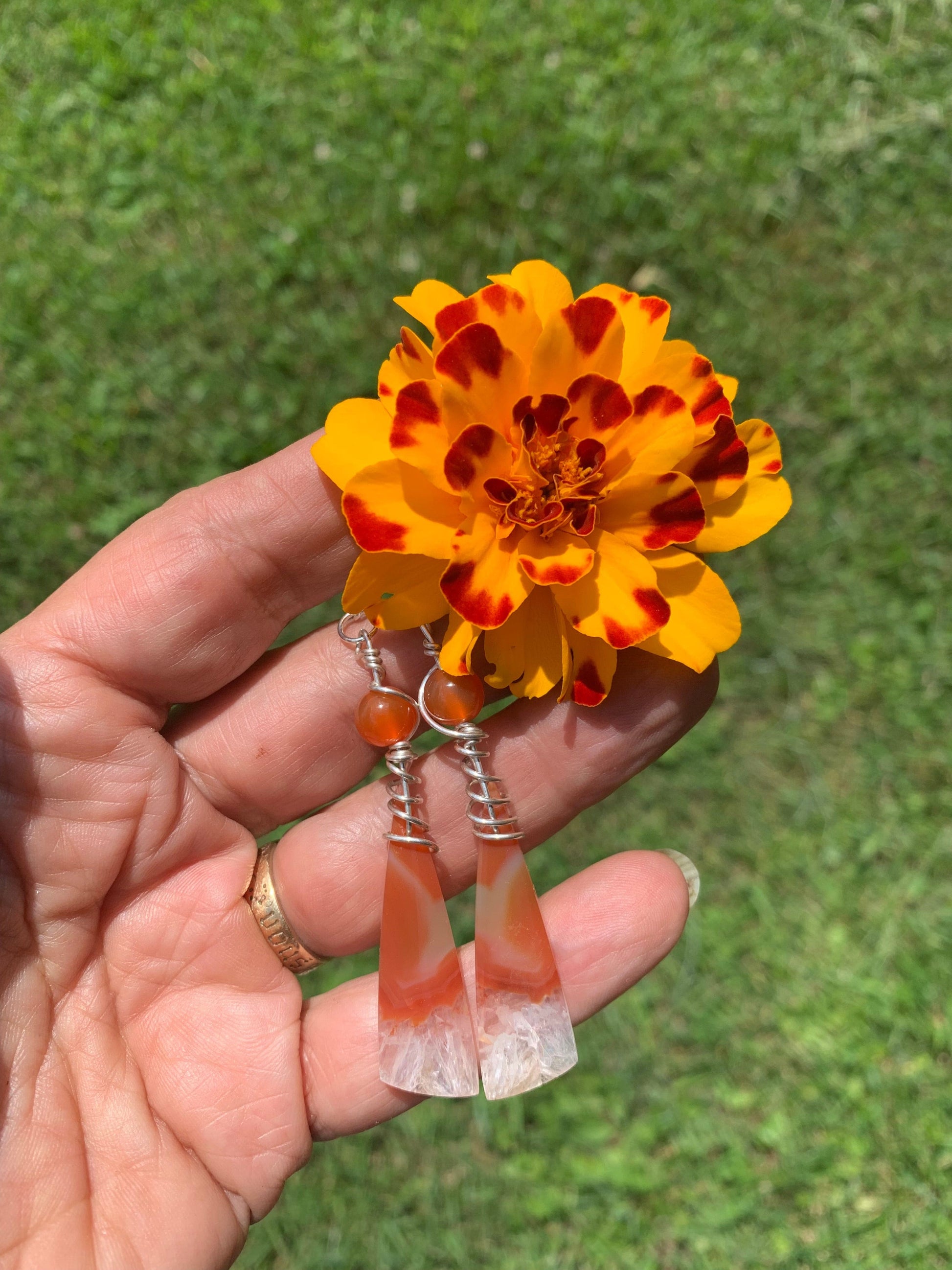 Carnelian Ice earrings held with marigold flower