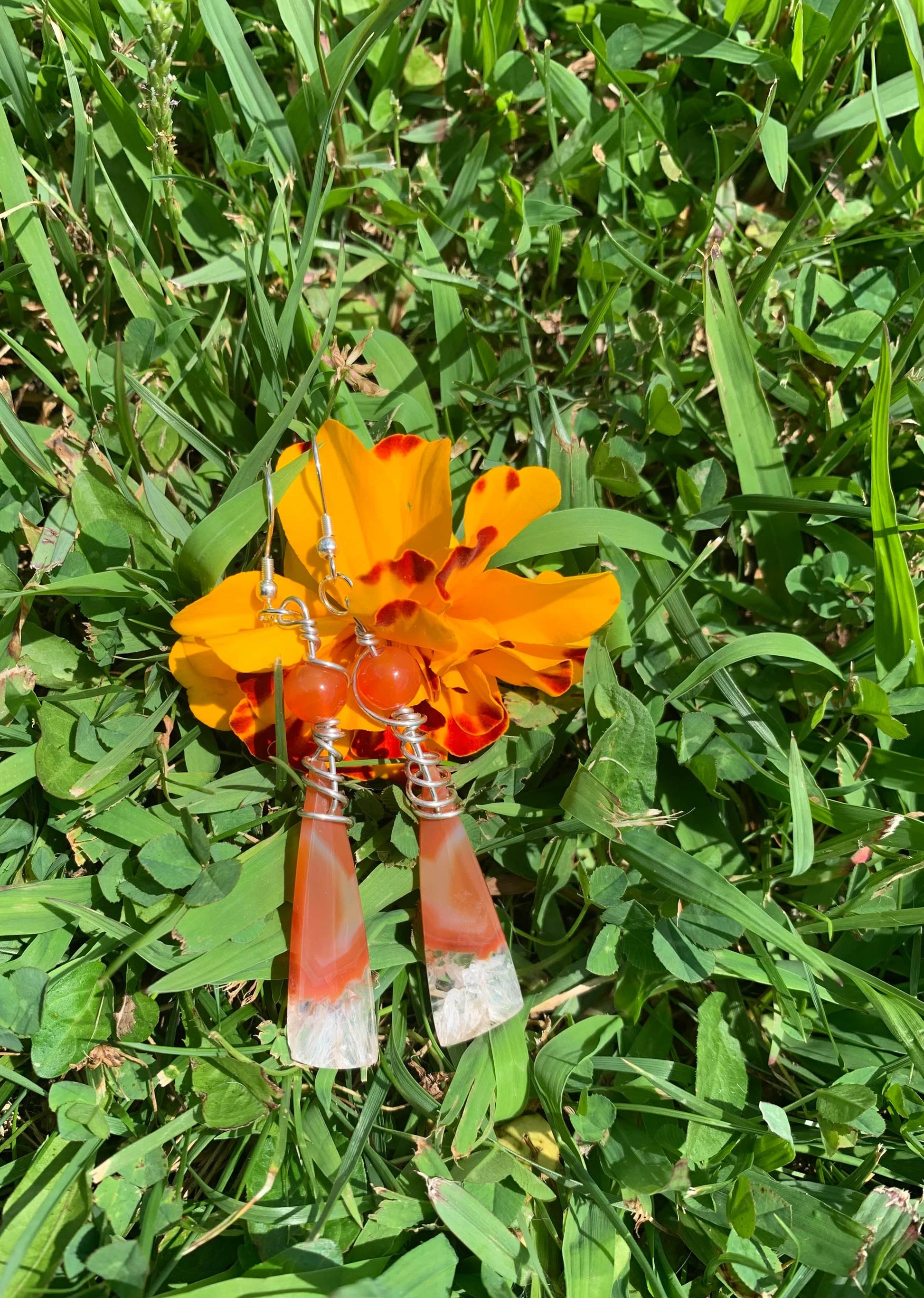 Carnelian Ice earrings on orange flower