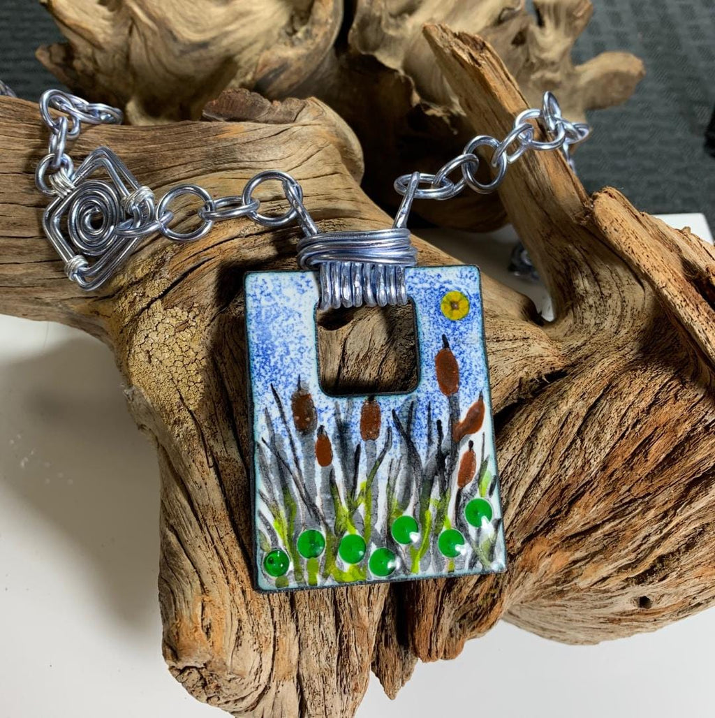 Cat Tails pond necklace with silver chain on driftwood