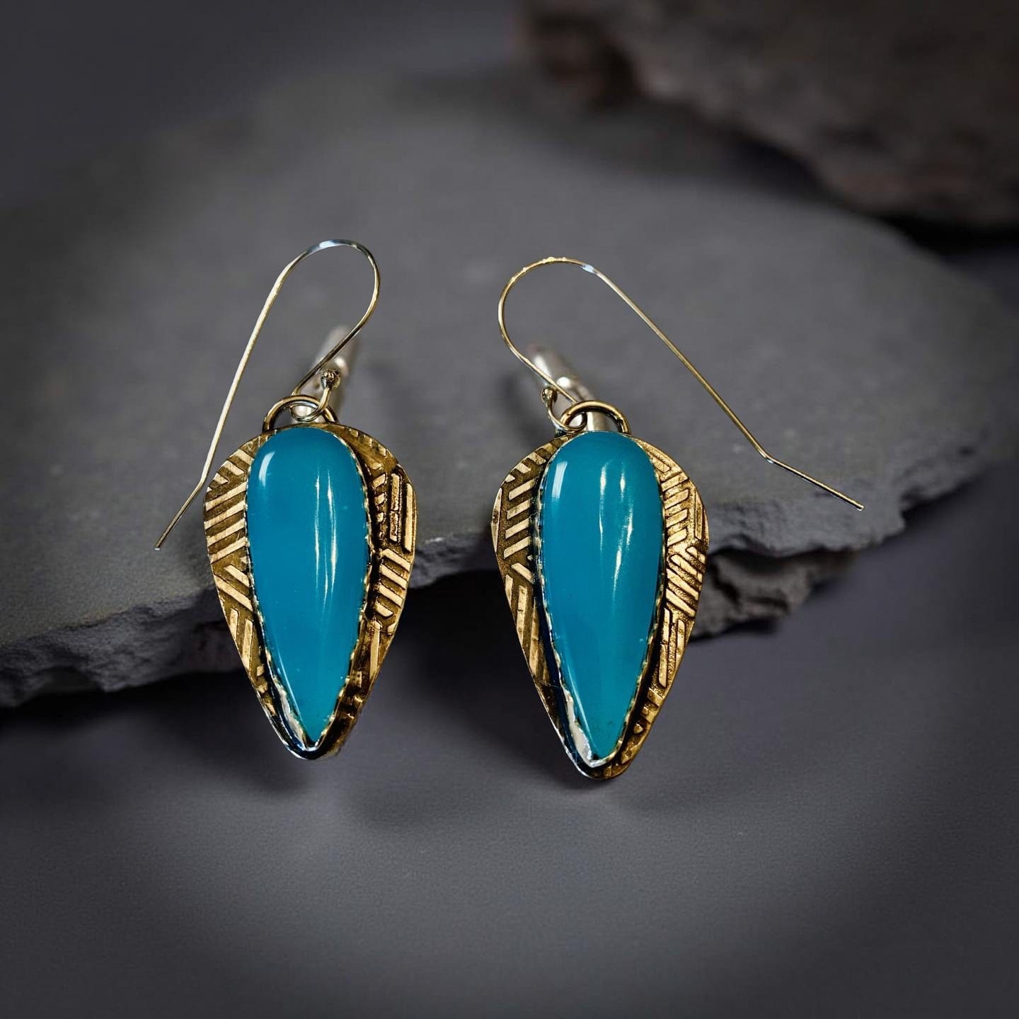 Turquoise earrings with Silver on a dark stone surface