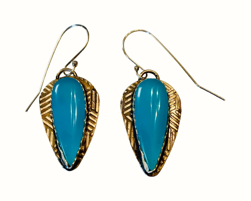 Pair of earrings with blue stones and set in silver on a white background