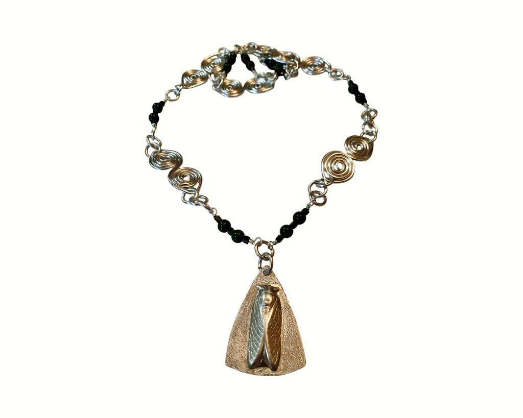 Necklace with black beads and a gold pendant on a white background