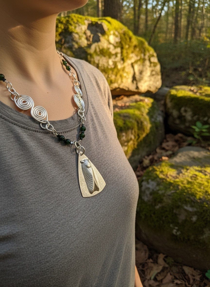 Person wearing a aluminum necklace with a pendant in a natural setting