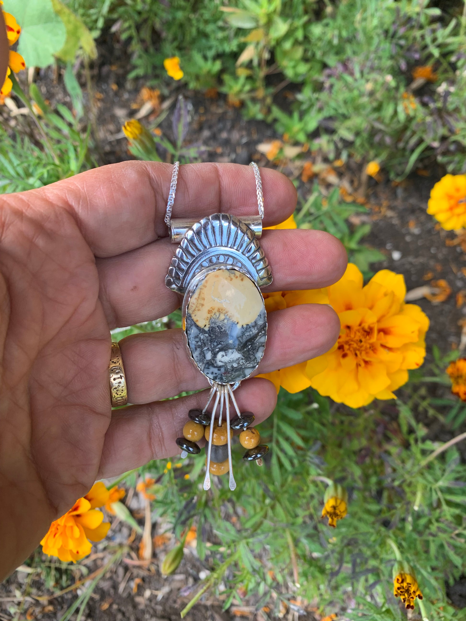 Hand holding pendant with flowers