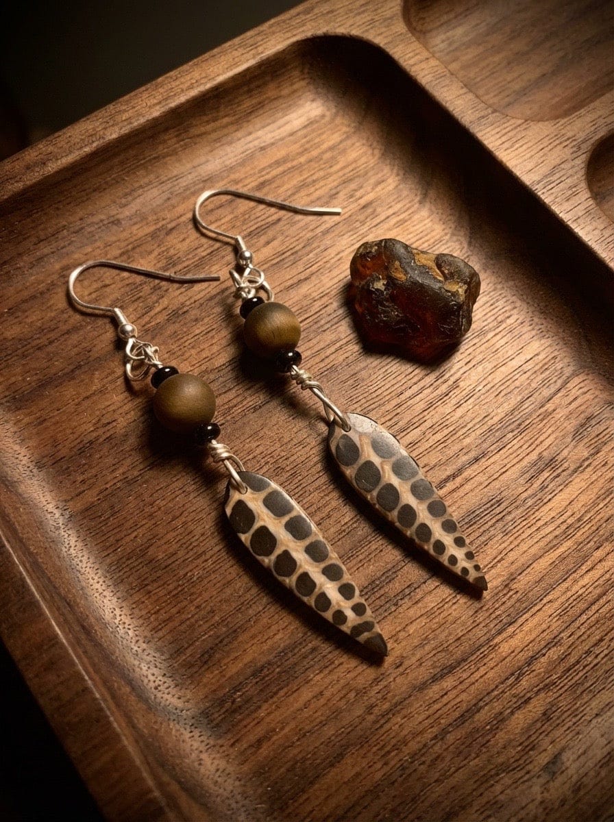 faux fossil silver earrings in a wooden tray