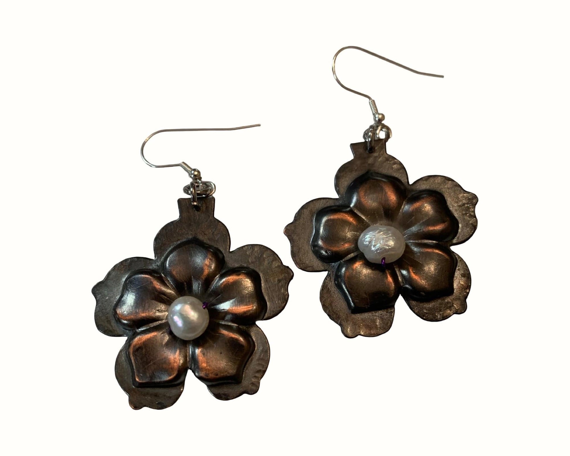 Pair of flower-shaped earrings with pearl centers on a white background