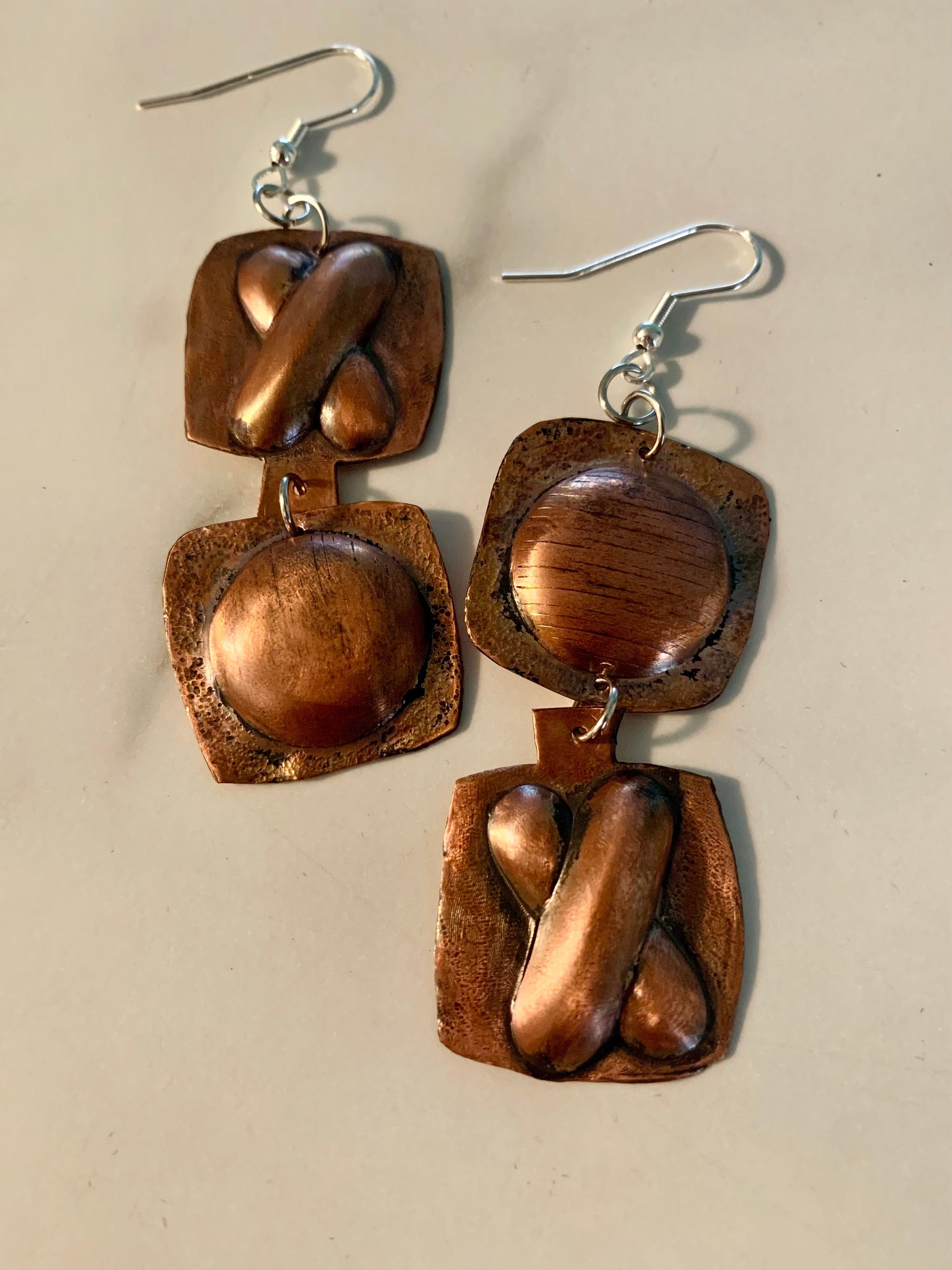 Copper earrings with geometric shapes.