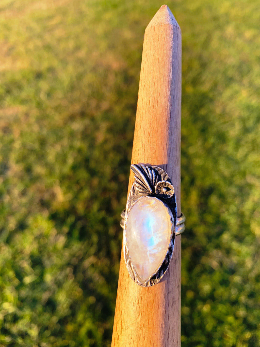Moonstone flower ring on wooden stand
