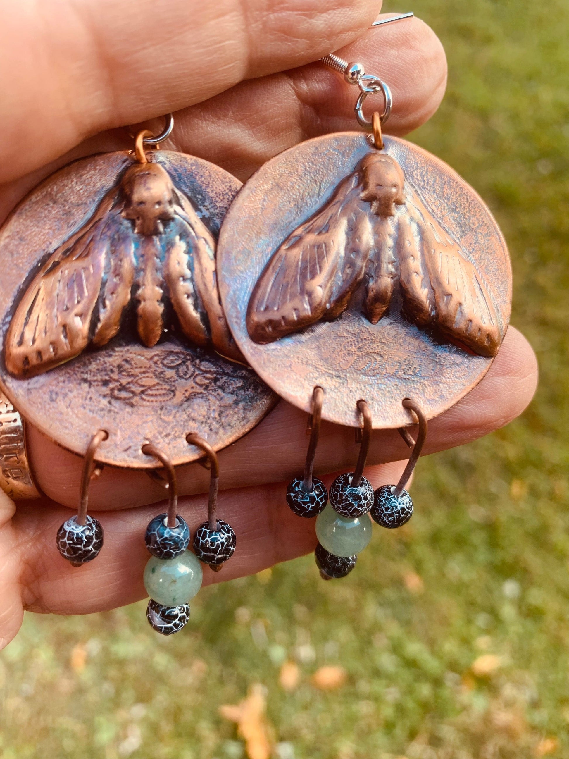 Moth earrings on textured copper