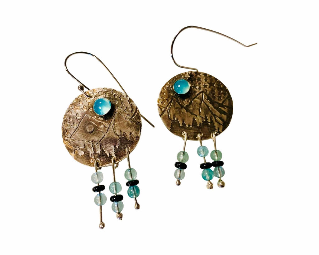 Pair of silver earrings with turquoise and green beads on a white background