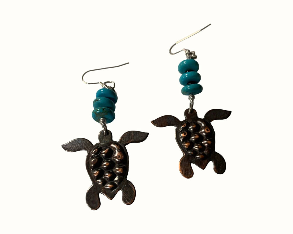 Turtle-shaped earrings with turquoise beads on a white background