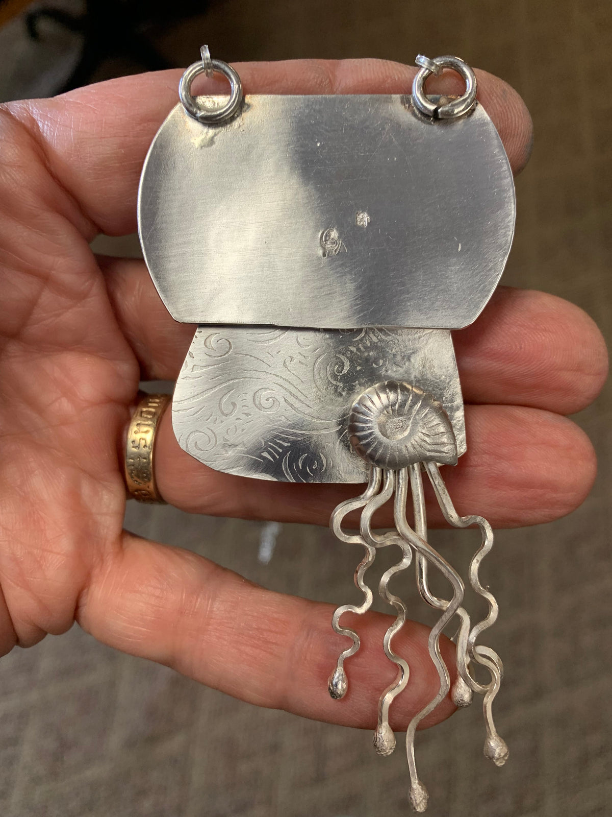  Back of Serenity sterling silver pendant showing Christine Keller artist mark textured silver and ammonite detail