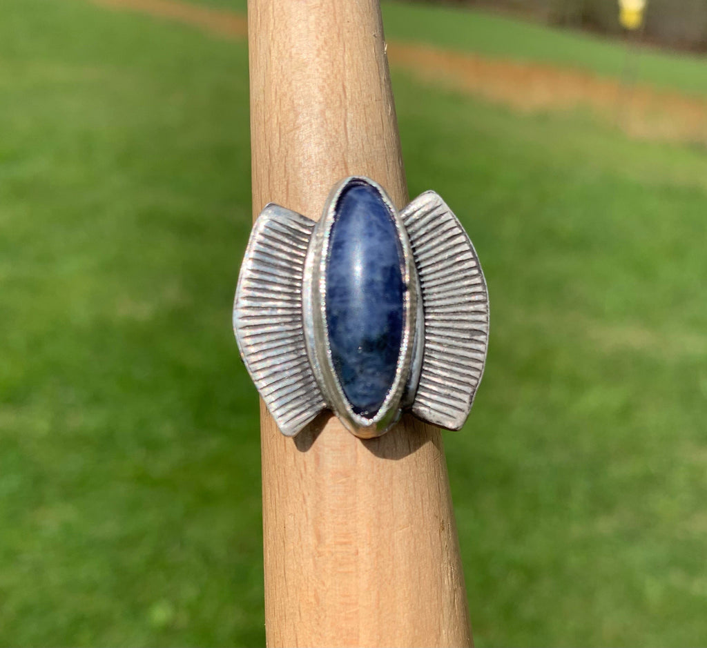 Sodalite Egyptian Ring, oval blue stone with silver wings, close-up.