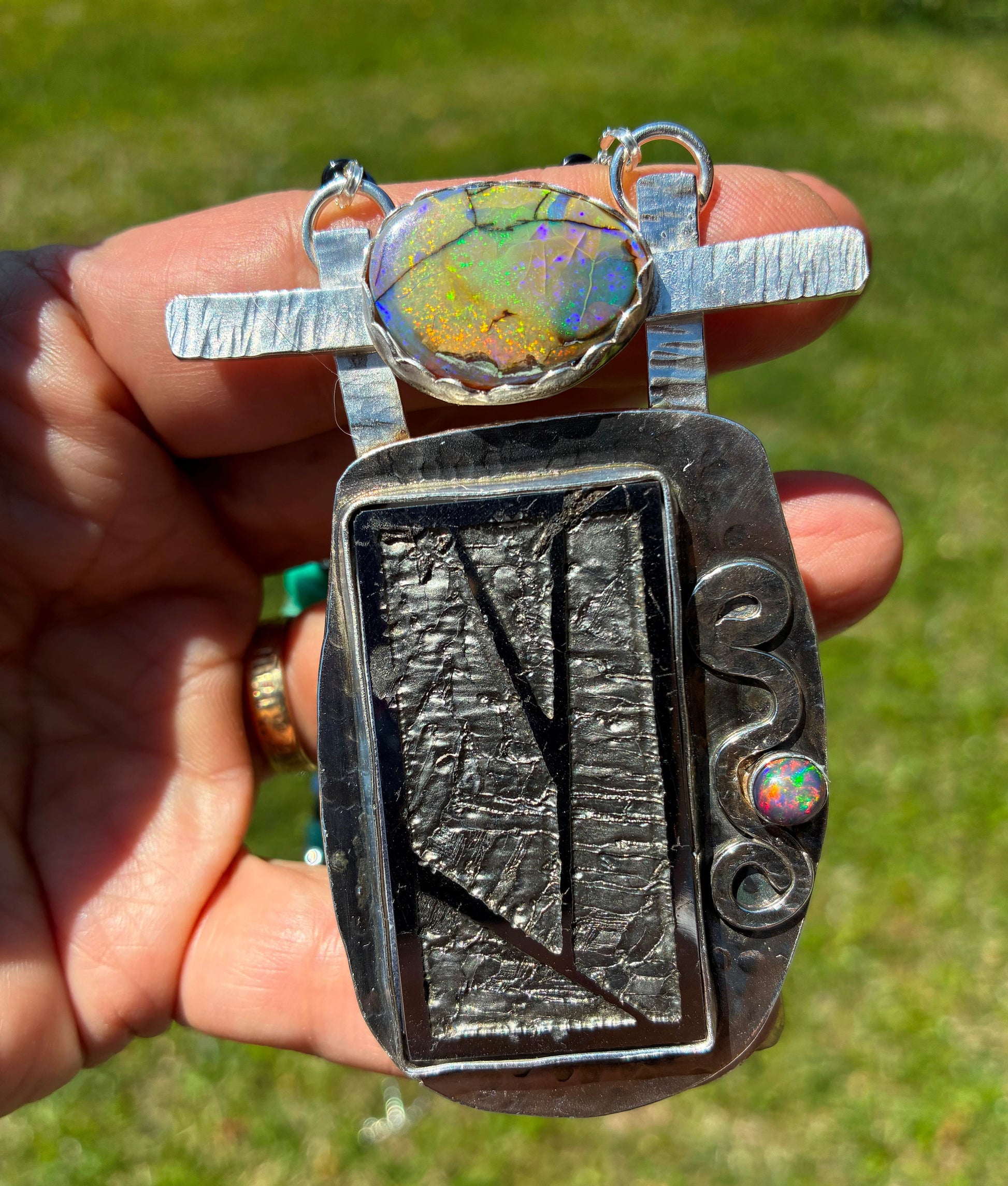closeup of Meteorite Pendant with opals on it