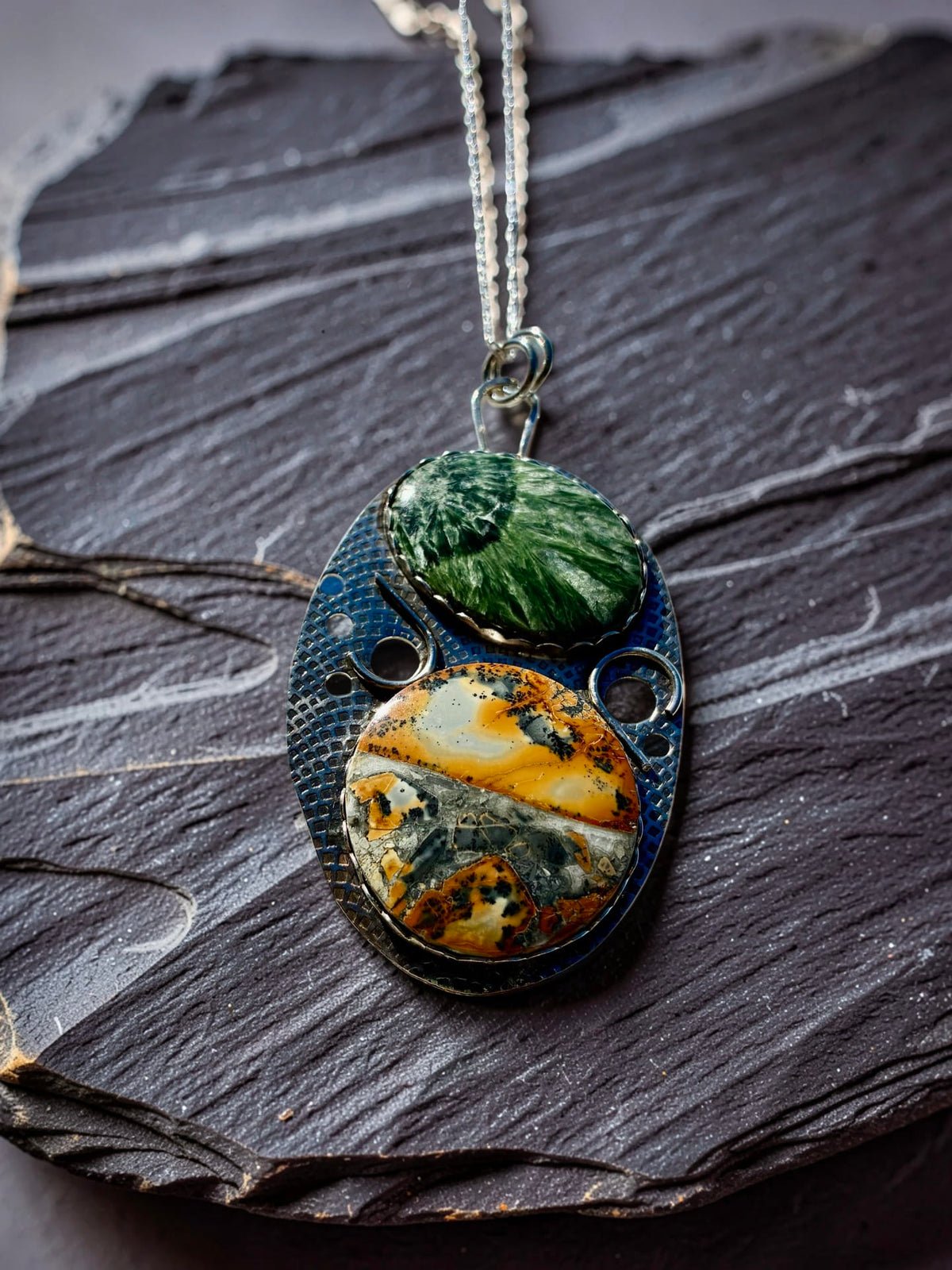 The Unfolding one-of-a-kind silver pendant by Christine Keller featuring green Seraphinite above golden Maligano Jasper in an original textured silver setting.