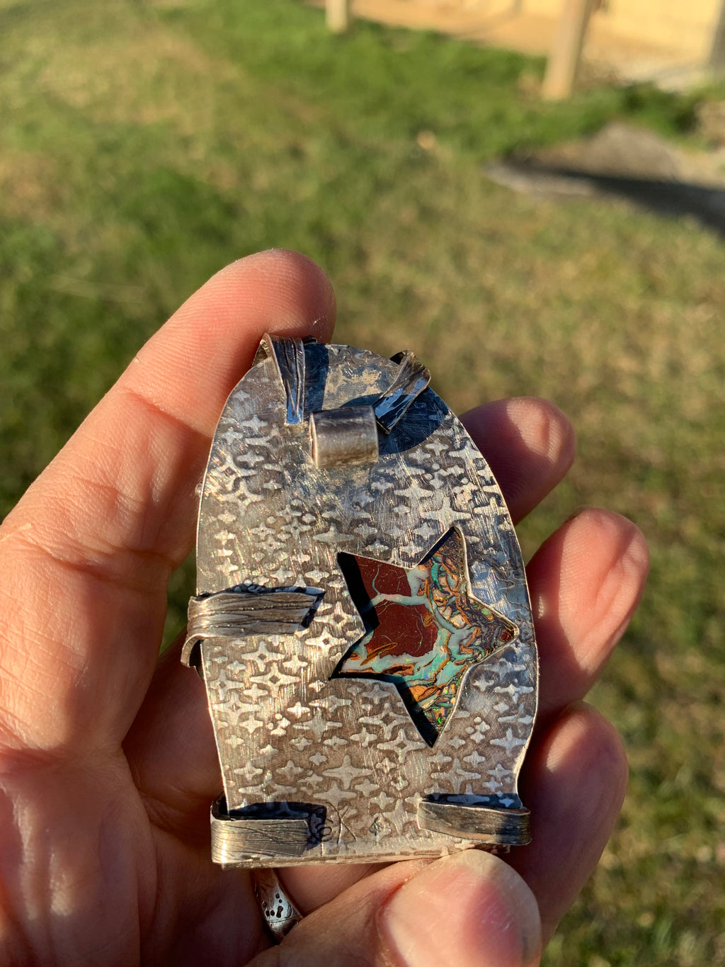 Back of Lightning Strikes showing textured sterling silver and cutout revealing the Boulder Opal