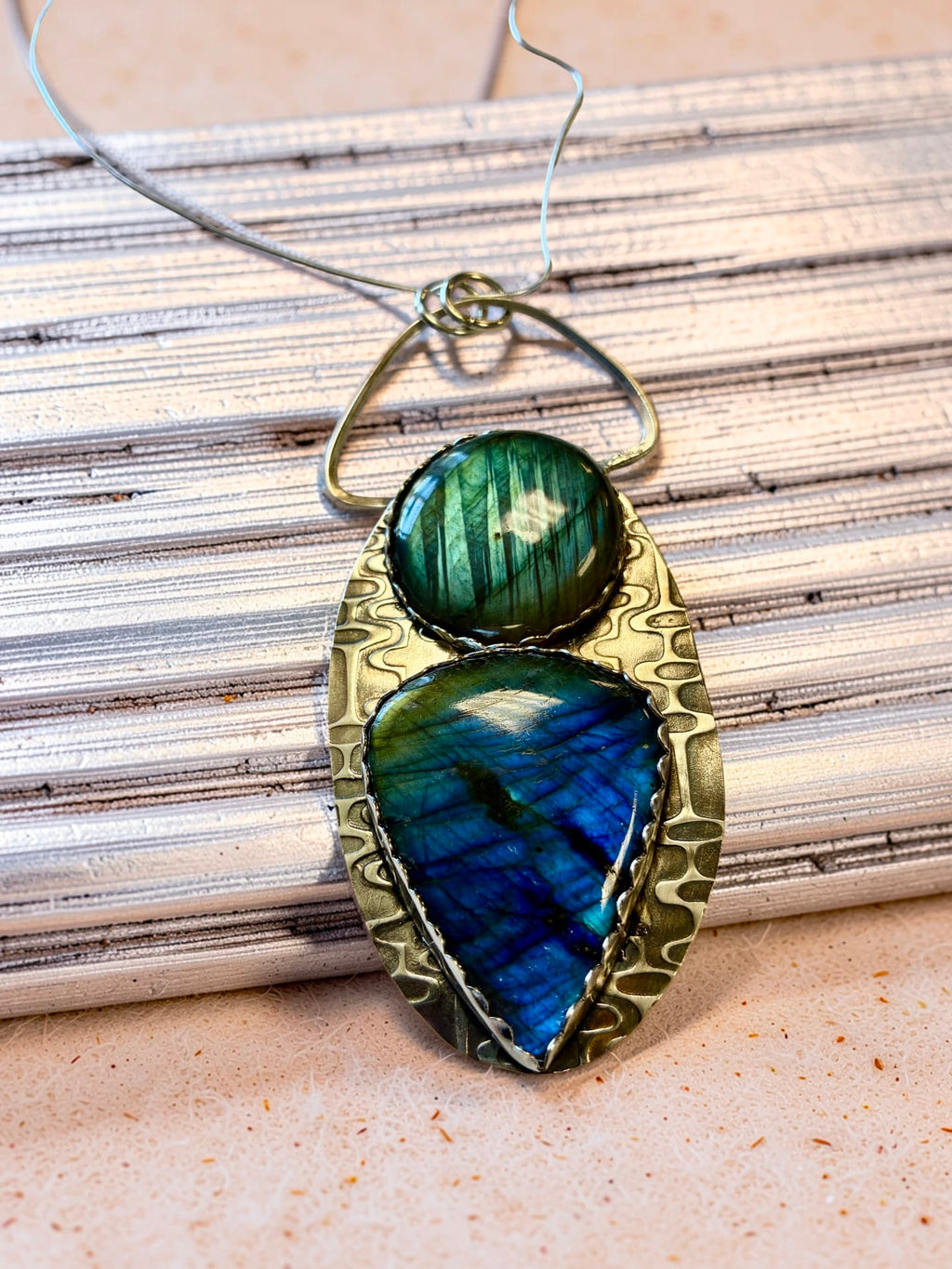 Two-stone labradorite art pendant displaying forest-green and brilliant blue flashes within a sculptural hand-textured sterling silver setting.