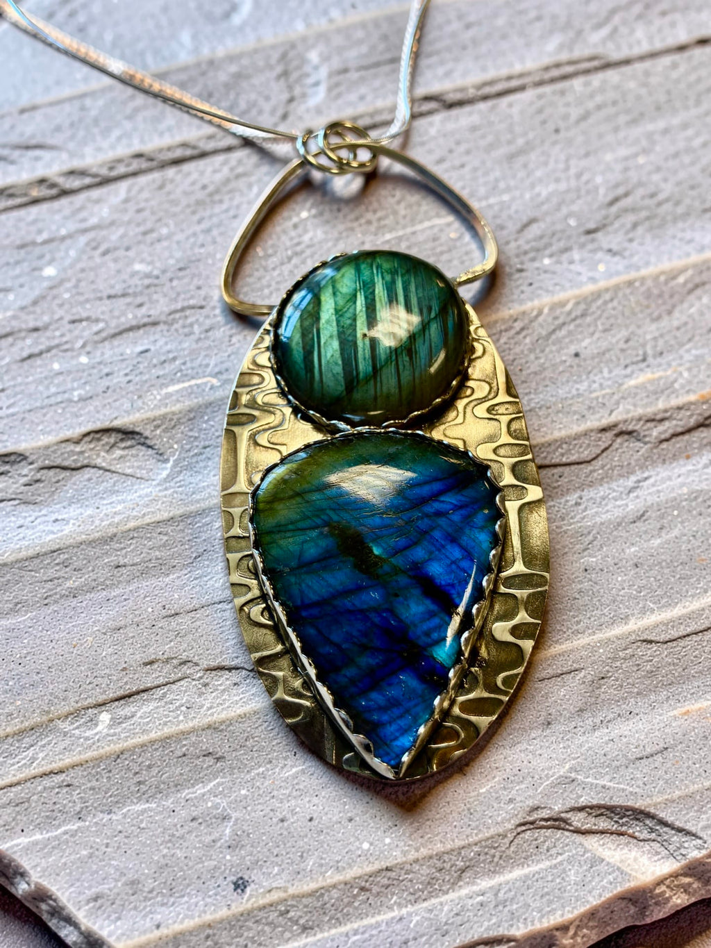 Two-stone labradorite art pendant displaying forest-green and brilliant blue flashes within a sculptural hand-textured sterling silver setting.