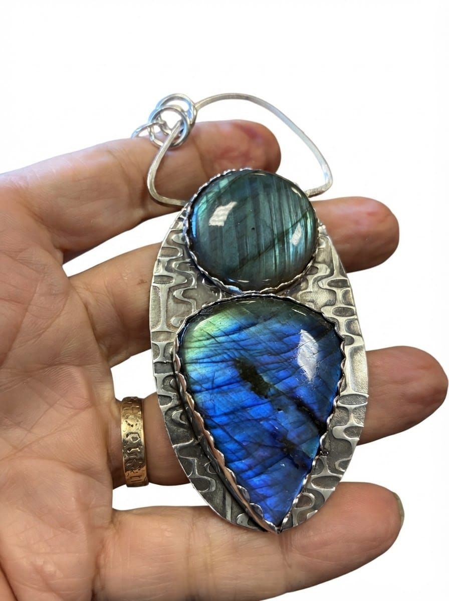 Large 4½-inch labradorite sterling silver statement pendant by Christine Keller, shown in hand to demonstrate its substantial scale.