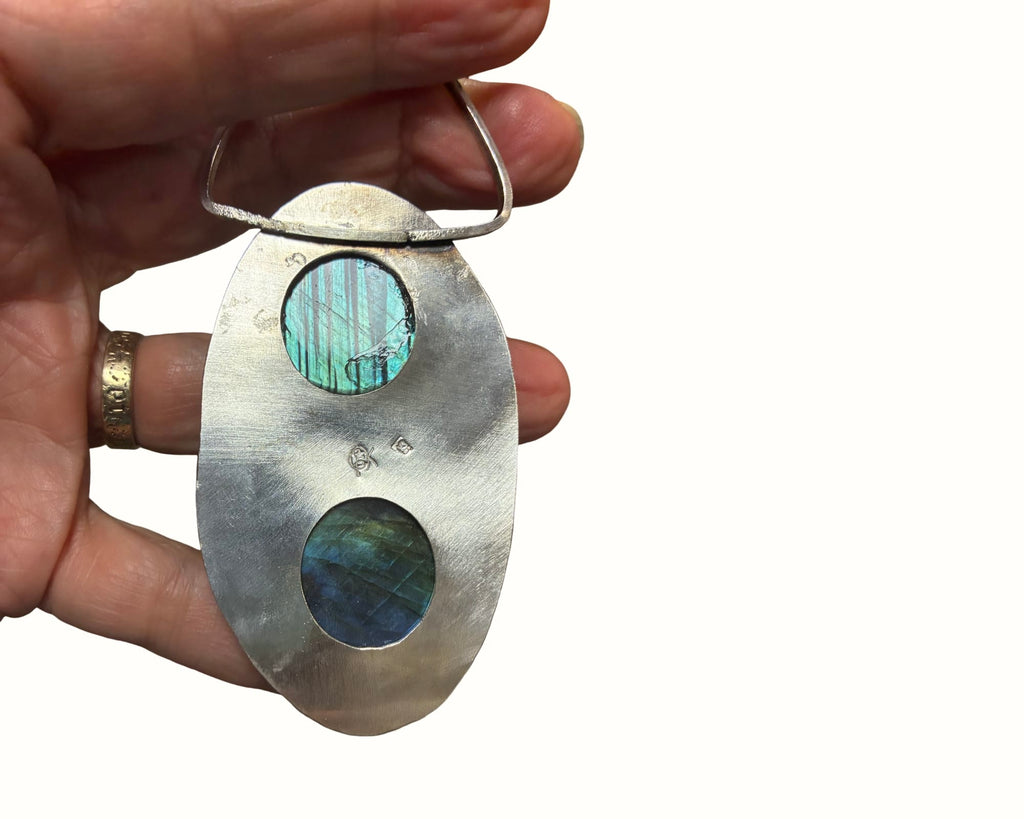 Reverse of Where the Earth Breathes pendant showing two open-back labradorite settings and Christine Keller's maker's mark in sterling silver.