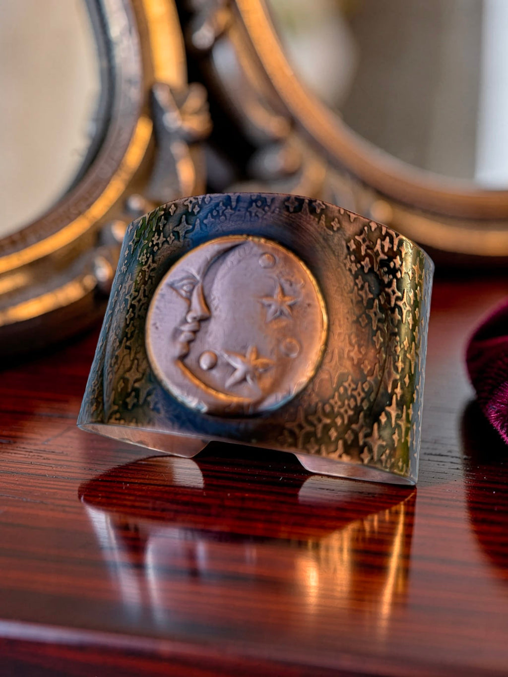 Whispers of the Moon handcrafted copper cuff bracelet by Christine Keller, featuring a moon face and stars with richly textured copper and dark patina.