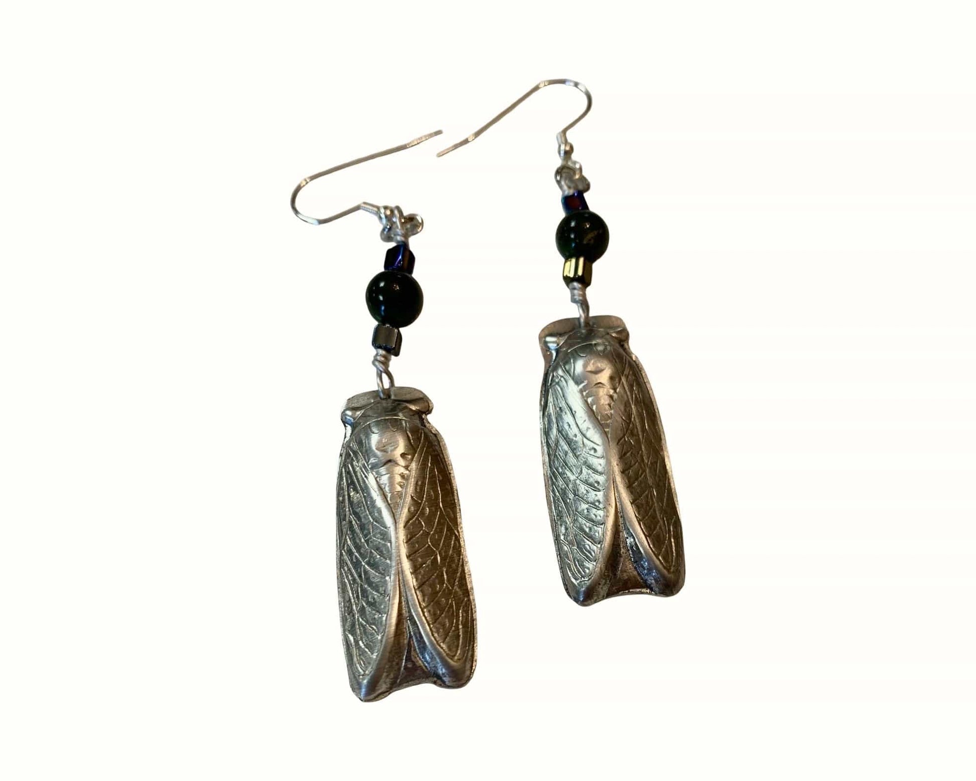 Pair of aluminum insect-wing shaped earrings with black beads on a white background