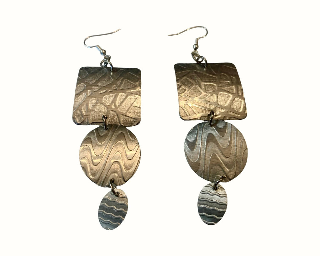 Pair of earrings with textured aluminum metal designs on a white background