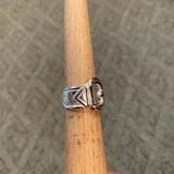 Silver buckle ring on wooden dowel
