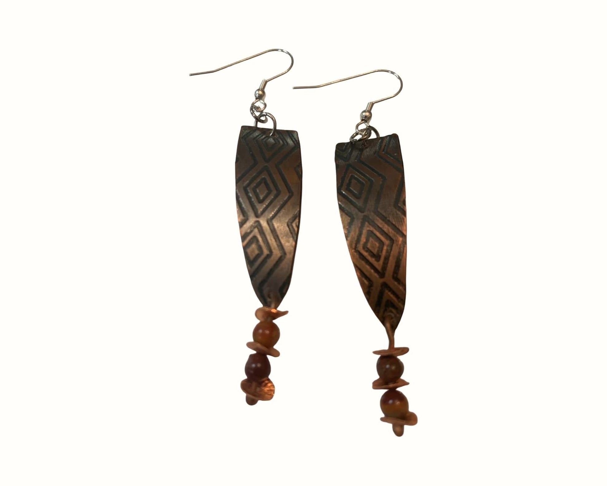 Pair of  Copper earrings with western design and jasper beads on a white background